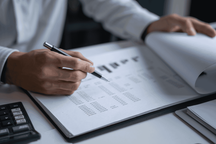 Expert financier analysant un rapport comptable pour évaluer les risques clients avant de souscrire une assurance-crédit.