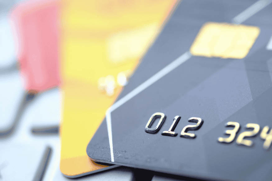 Primo piano di più carte bancarie sovrapposte, immagine che rappresenta la scelta tra carta a debito immediato e carta a debito differito in base al budget personale.