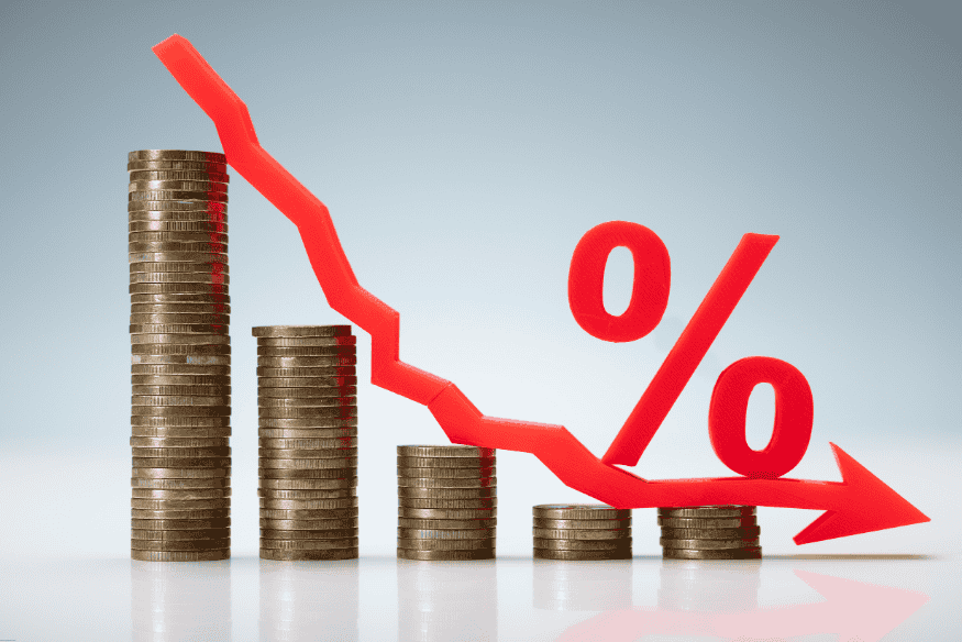 Graphique symbolisant la baisse des taux d’intérêt avec une flèche rouge descendante et des piles de pièces.